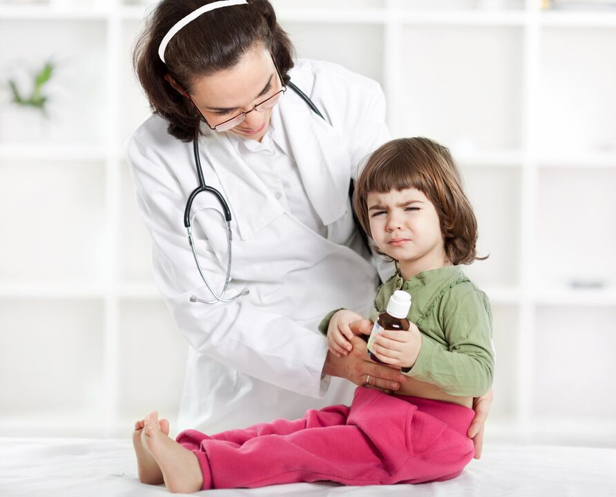 o médico examina o neno para detectar síntomas de vermes